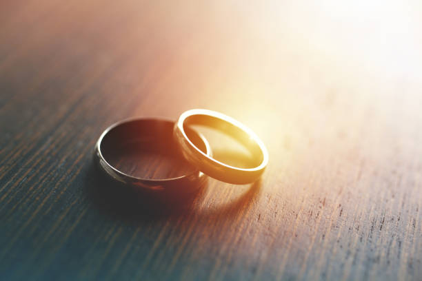 Wedding Rings Close-up of wedding rings on table with sunlight. wedding ring stock pictures, royalty-free photos & images