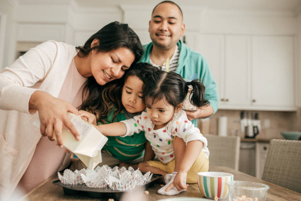 Weekend family time Family of four baking together filipino family stock pictures, royalty-free photos & images