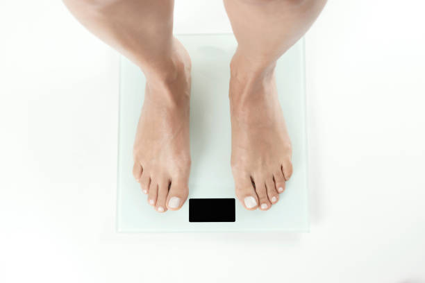 Weighing Scale Barefoot female on weighing scale. feet unit of measurement stock pictures, royalty-free photos & images