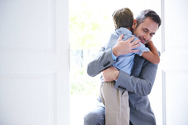 Welcome home! Shot of a father embracing his little boy as he arrives home from workhttp://195.154.178.81/DATA/i_collage/pu/shoots/784407.jpg worker returning home stock pictures, royalty-free photos & images