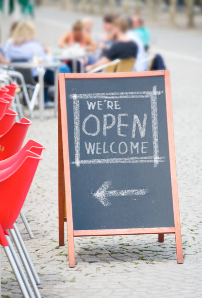 Welcome open sign, restaurant or cafe ready to service after corona lockdown,  food and drink concept,billboard, sandwich board in a cafe outside stock photo