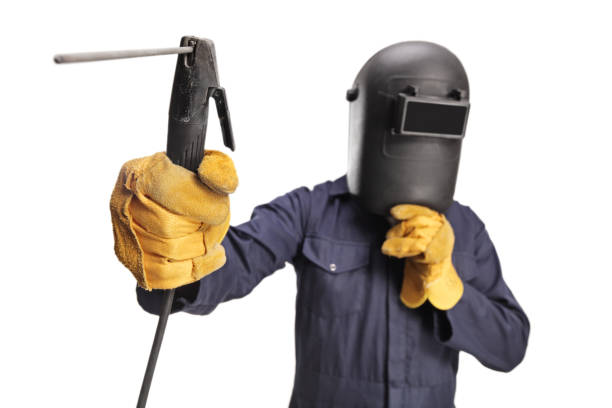 Welder with a face shield using a welding machine stock photo