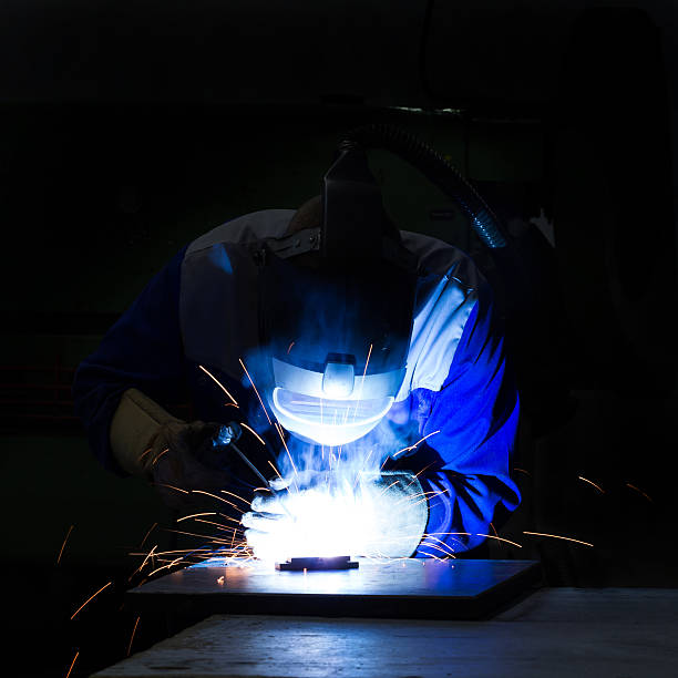 Welder with sparks in Darkness stock photo