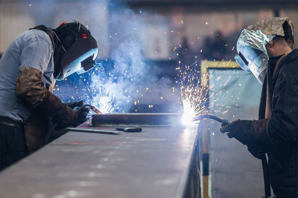 Welders working in workshop, Men using welding torch to cut metal sheet in workshop. sheet metal stock pictures, royalty-free photos & images