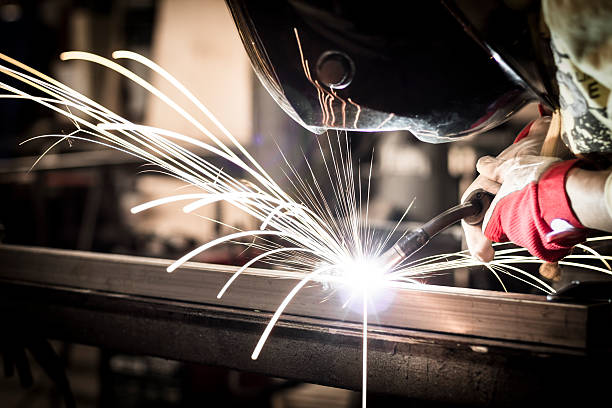 Welding steel Worker welding steel in company. metalwork stock pictures, royalty-free photos & images