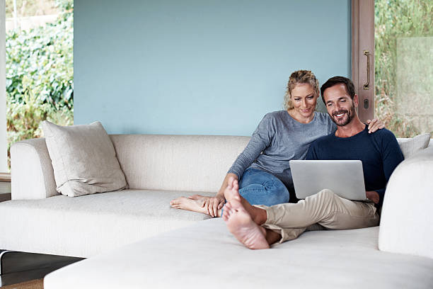We're enjoying our weekend surfing Full length shot of a couple using a laptop while relaxing on the sofahttp://195.154.178.81/DATA/i_collage/pu/shoots/804607.jpg laptop couple stock pictures, royalty-free photos & images