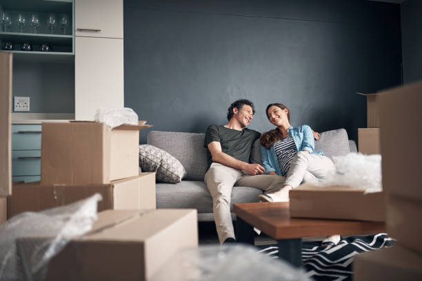 We're going to enjoy turning this house into a home Shot of a couple taking a break while moving house unpacking stock pictures, royalty-free photos & images