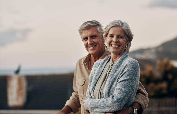 We're happy to be celebrating yet another new year together Cropped portrait of an affectionate mature couple smiling while standing on a balcony outdoors mature couple stock pictures, royalty-free photos & images