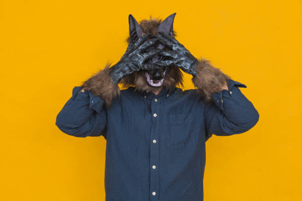 A werewolf covering his eyes with his hands stock photo