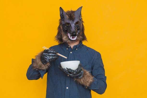 A werewolf eating out of a bowl with chopsticks stock photo