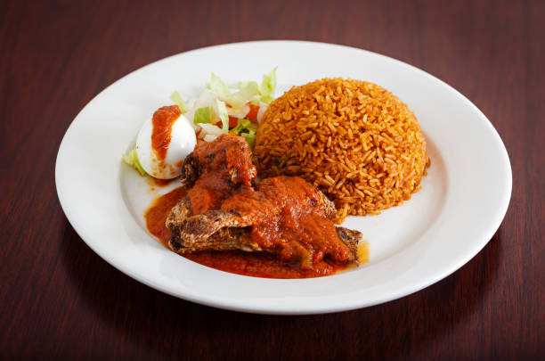 West African entree of jollof rice, fish and salad stock photo