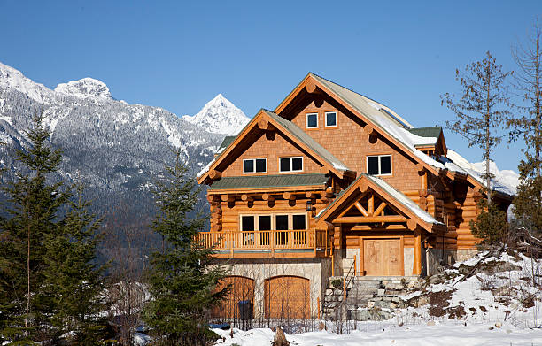 A west coast wooden house during winter in mountains A house typical of west coast architechture, sits against the backdrop of the Tantalus Range in Squamish, British Columbia. log cabin stock pictures, royalty-free photos & images