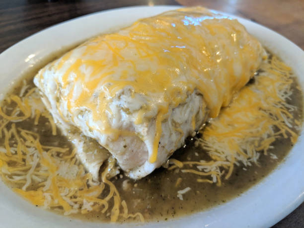 Wet Burrito with Green Sauce and cheese on top stock photo