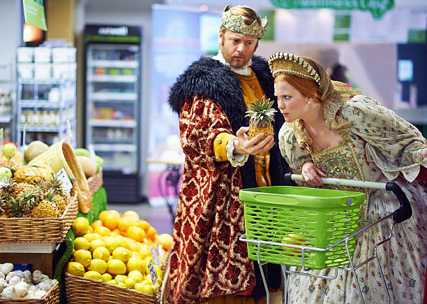 What does one do with this strange item? A view of a king and queen in the supermarket feeling puzzled by the produce snob stock pictures, royalty-free photos & images