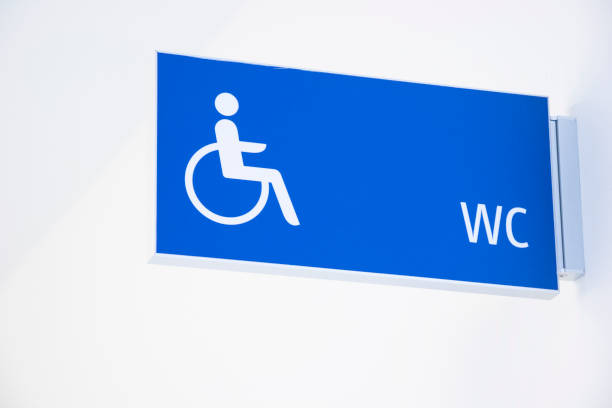 icône de l’utilisateur du fauteuil roulant sur le signe de toilette bleu - handicap photos et images de collection