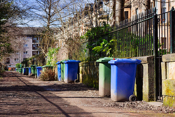 Wheelie Bins Wheelie bins (blue for recycling, green for general refuse) lined up for collection in a Glasgow alley. theasis stock pictures, royalty-free photos & images