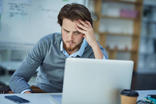 When work is working against you Shot of a young businessman experiencing stress in a modern office dissatisfied employee stock pictures, royalty-free photos & images
