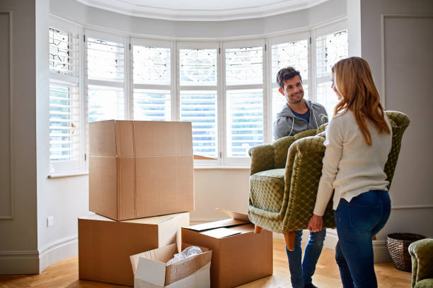 Where is this going to go? Shot of a happy young couple carrying a chair in their new house unpacking stock pictures, royalty-free photos & images