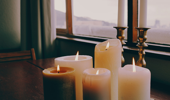 Shot of lit candles on a table in a modern apartment