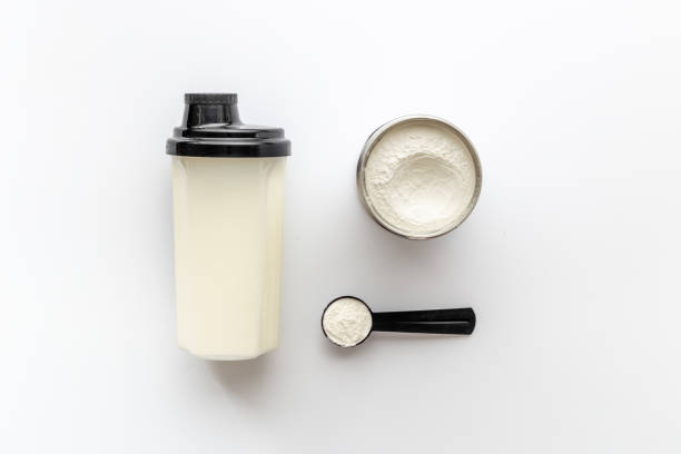 proteína de suero de leche en polvo en cucharada y agitador con nutrición deportiva - proteina de suero de leche fotografías e imágenes de stock