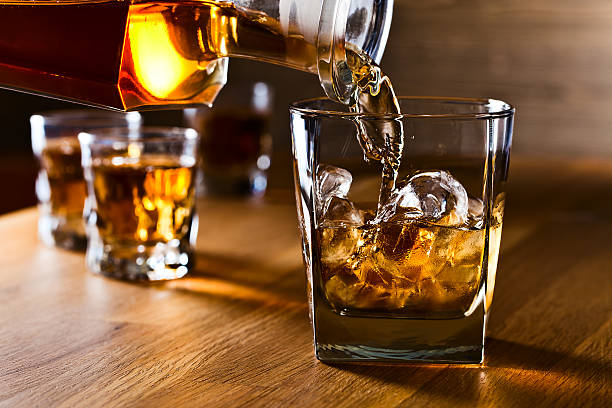 whiskey and natural ice - gieten stockfoto's en -beelden