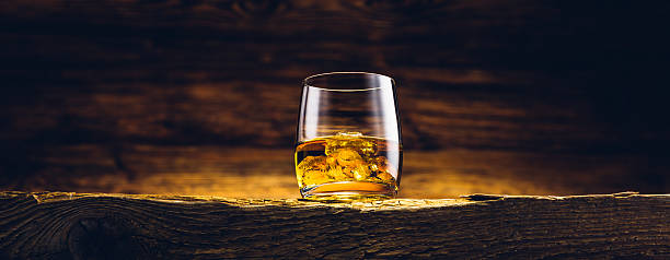 Whiskey glass on the old wooden table stock photo