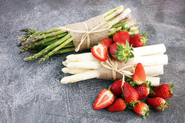 White and green asparagus with strawberries stock photo