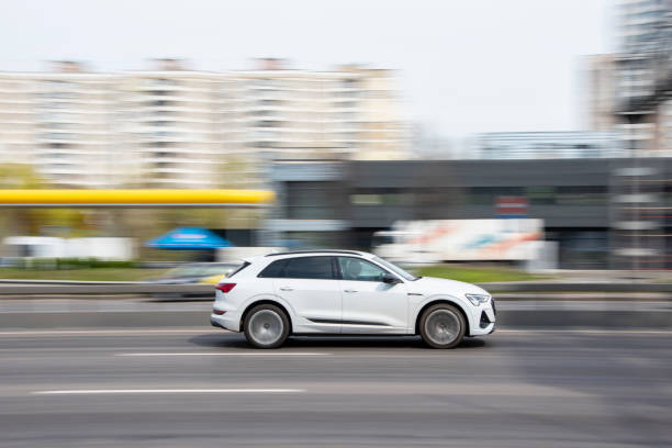 White Audi e-tron car moving on the street. Ukraine, Kyiv - 20 April 2021: White Audi e-tron car moving on the street. Editorial audi photos stock pictures, royalty-free photos & images