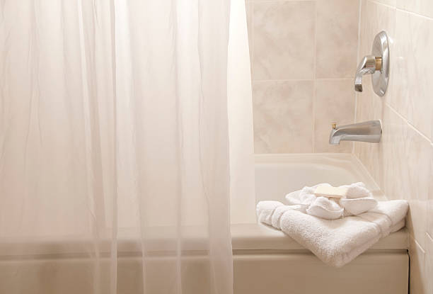 White bathroom with bathtub, towels and a shower curtain stock photo