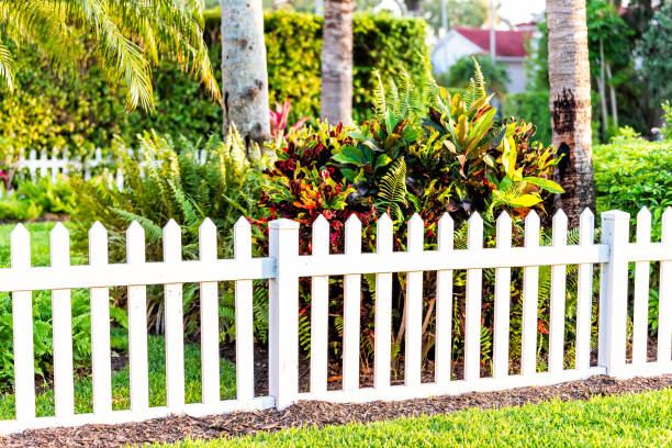 White beach wooden wood architecture picket fence of house in front porch yard garden with green landscaping trees vacation cottage home closeup White beach wooden wood architecture picket fence of house in front porch yard garden with green landscaping trees vacation cottage home closeup naples florida beach photos stock pictures, royalty-free photos & images