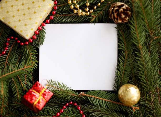 White blank sheet around branch of Christmas tree and New Year's decorations. stock photo