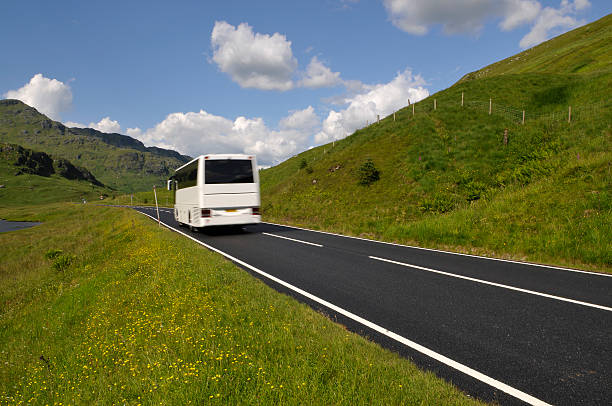 White bus on mountain road stock photo