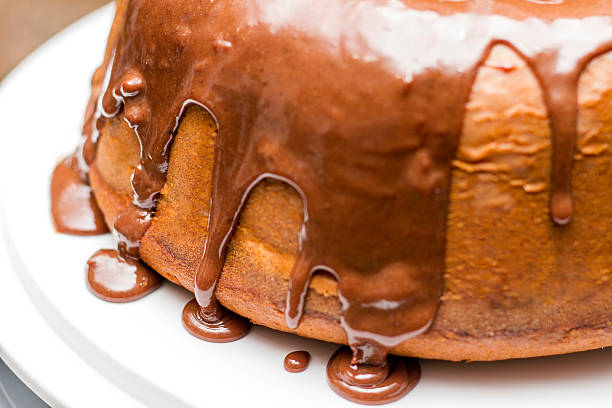 White cake with melted chocolate syrup on top stock photo