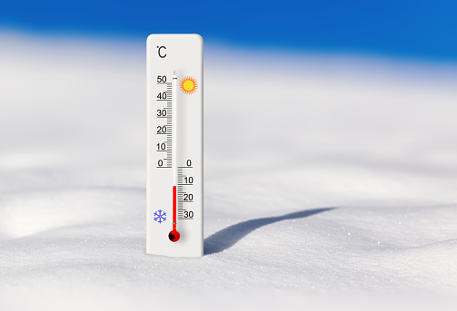 White celsius scale thermometer in the snow. Ambient temperature minus 11 degrees