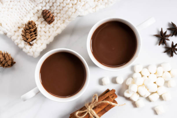 white ceramic cups of hot cocoa on top of white marble background, top view - hot chocolate imagens e fotografias de stock