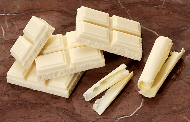 White chocolate chunks and shavings on brown marble stock photo