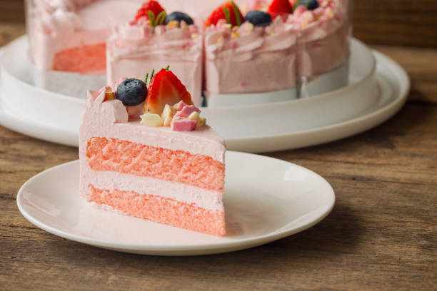 白巧克力草莓優酪乳蛋糕用新鮮水果和巧克力塊裝飾在木桌上。美味和甜美的粉紅色蛋糕情人節或生日聚會。自製的烘焙概念。 - cake 個照片及圖片檔
