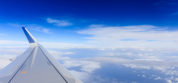 Fluffy white clouds on a blue sky from a plane window background. Space for text.