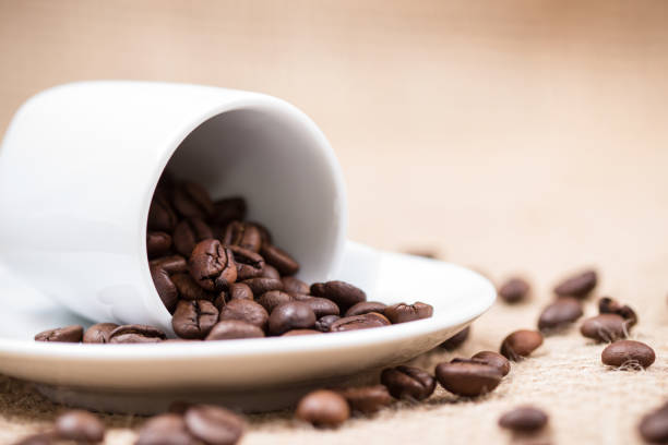 White coffeecup with coffeebeans on gunny background stock photo