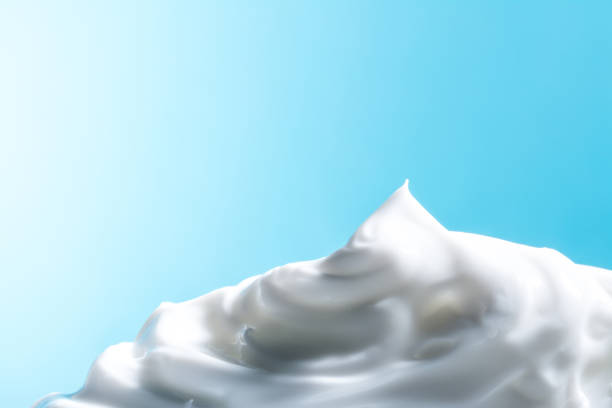 vit kosmetiska grädde närbild makro textur på blå bakgrund - whipped cream bildbanksfoton och bilder