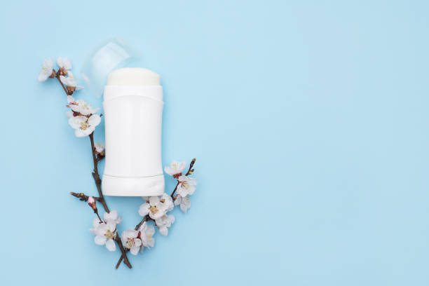 White deodorant and flowers on blue background . flat lay composition with copy space . White deodorant and flowers on blue background . flat lay composition with copy space . deodorant stock pictures, royalty-free photos & images