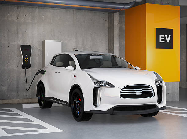 White electric SUV recharging in parking garage stock photo