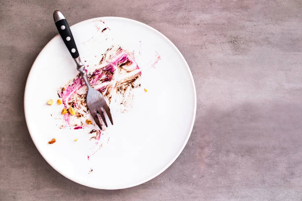 White empty plate with piece of cake leftovers White empty plate with piece of cake leftovers from above on gray background. Copyspace for text eaten stock pictures, royalty-free photos & images
