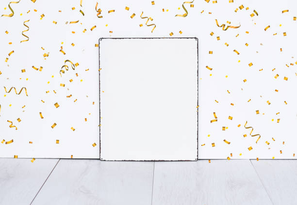 White empty sign board on wood against white wall background with gold color party confetti mock up for birthday or celebration party stock photo