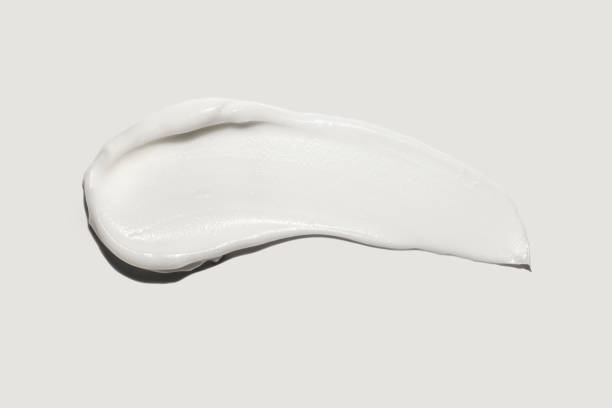 White foam clay cream mask sample textured foundation isolated on multi-colored background stock photo