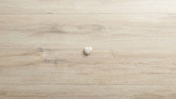 White heart made of stone lying on a woodenk desk stock photo