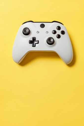 White joystick gamepad, game console on yellow colourful trendy modern fashion pin-up background. Computer gaming competition videogame control confrontation concept. Cyberspace symbol