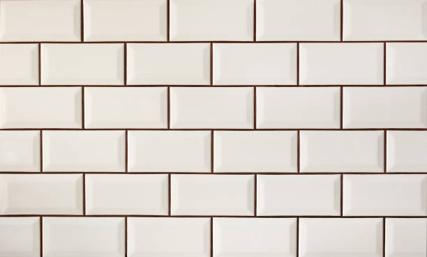 White metro tiles patterned wall. Beige ceramic brick tiles background. stock photo