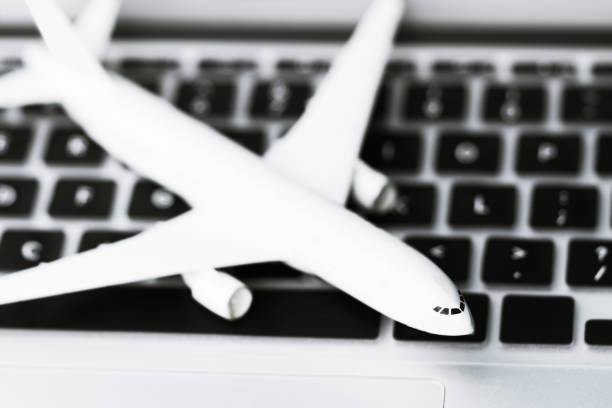 White model airplane lands on a laptop keyboard. stock photo