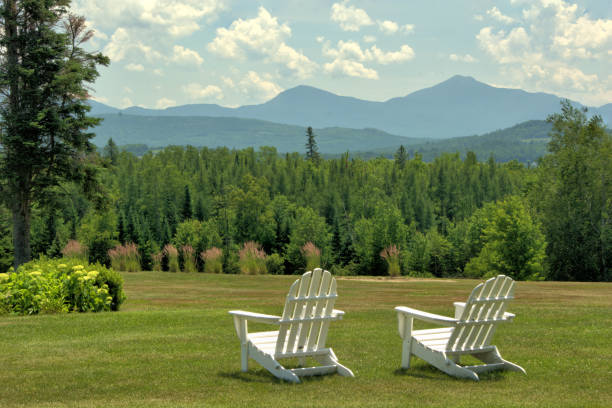 White Mountains from Whitefield New Hampshire Scenic vista along Mountain View Road in Whitefield, New Hampshire. White lawn chairs overlooking hillside of lush evergreen trees framed by distant mountains in the Presidential Range. new hampshire stock pictures, royalty-free photos & images
